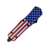 7‑inch automatic OTF knife with American flag handle shown in the closed position with the blade fully retracted.