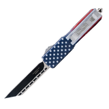 American flag OTF knife displayed with its deployed tanto blade and the integrated belt clip highlighted along the handle.