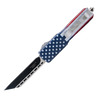 American flag OTF knife displayed with its deployed tanto blade and the integrated belt clip highlighted along the handle.
