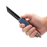 8.5‑inch automatic OTF knife with American flag handle shown in hand to display size, grip, and the extended tanto blade.