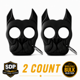 Two black Brutus self‑defense keychains shaped like stylized dog heads with pointed ear impact tips, shown together as a 2‑pack.