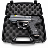 Firestorm JPX 6 black pepper spray gun with integrated laser shown inside its hard carry case with molded interior compartments.