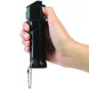  Close view of a person gripping the Mace 3‑in‑1 Police pepper spray, showing thumb placement for lifting the flip‑top safety cover.