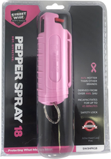 Pink pepper spray keychain displayed in retail packaging with clear blister front and printed safety information.