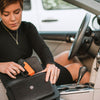 Trigger‑grip SABRE Aim & Fire pepper gel positioned in a purse compartment, highlighting accessibility and compact design.