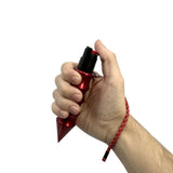 In‑hand view of a self‑defense hammer spray highlighting the integrated pepper spray and the forward DNA‑recovery point.