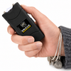 A hand holding a black pet stun gun with a visible LED light on the front, featuring the 'Smart Vet' and 'SMACK PRODOG' branding. The hand is wearing a gray knit sweater and silver bangles with a dog tag charm.