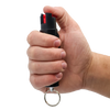 Streetwise 18 stream pepper spray (0.75‑oz) shown in hand with the key ring and clip visible to illustrate size and grip.