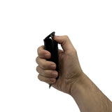 Sticky gel pepper spray nozzle detail with safety mechanism visible held in hand ready to activate.
