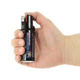 In‑use demonstration of the Streetwise 2‑ounce twist‑lock stream pepper spray with visible spray discharge