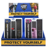 Ten‑pack Streetwise stream pepper spray shown in a countertop display box with each canister visible in its packaging mic colors of black and pink.