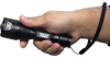 black flashlight with textured grip held in hand