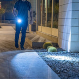 “TASER StrikeLight 2 shining a beam of light in a dark outdoor setting.”