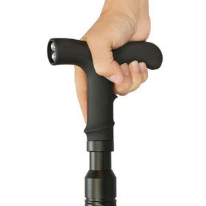  Hand gripping the handle of the ZAP Covert Cane disguised stun gun, showing the curved cane handle and integrated flashlight.
